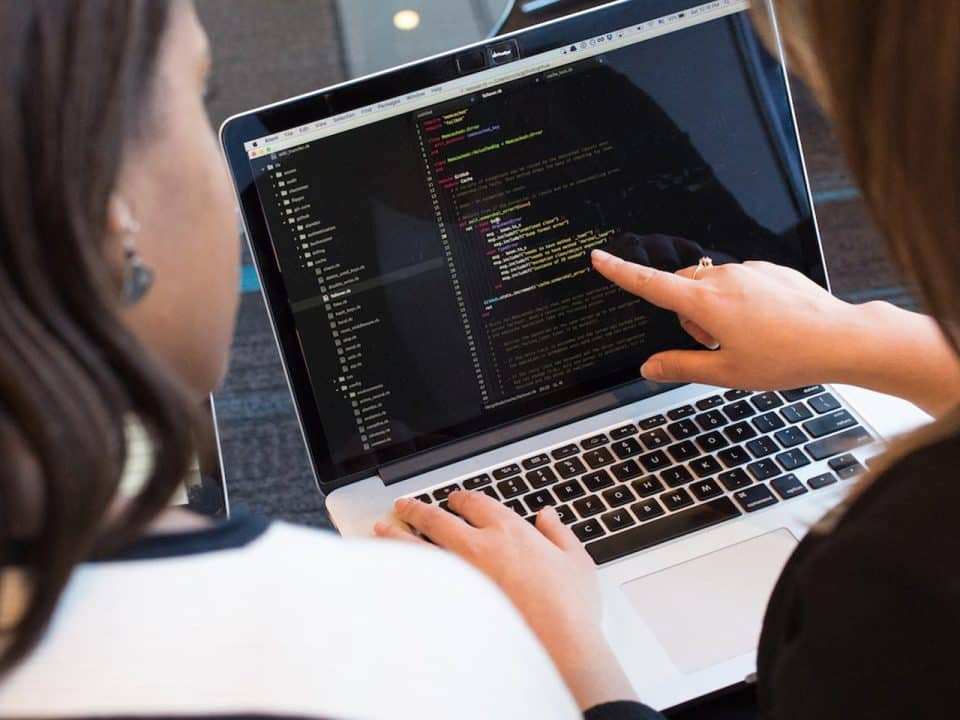 deux femmes sont en train de configurer les interfaces informatiques d'un client sur ordinateur